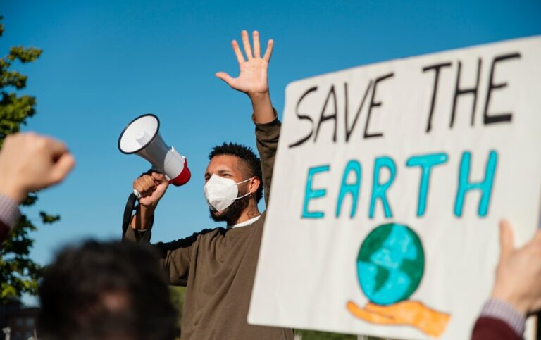 persone-con-maschera-alla-protesta-ambientale_23-2148970953