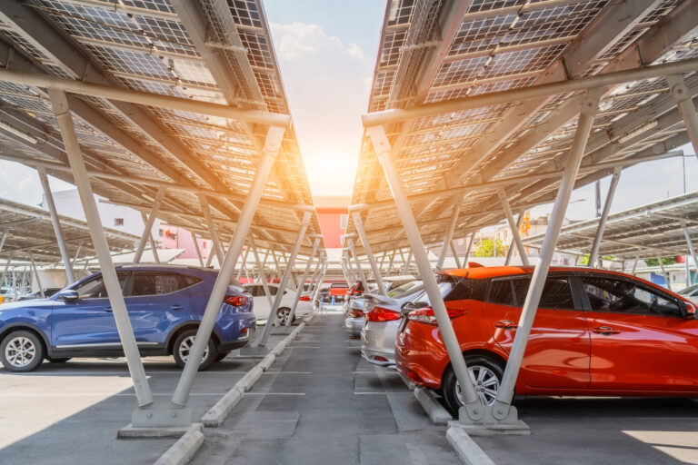 Solar panels installed over parking lot with parked cars for effective generation of clean energy